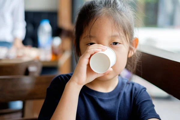 Asiatiska barn dricksvatten från papper kopp — Stockfoto