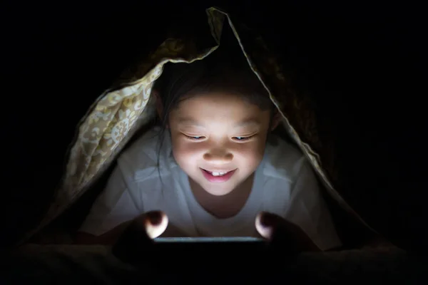 Asiatiska barn använda TabletPC i sängen på natten — Stockfoto