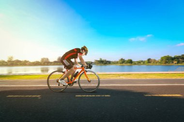 Adam binicilik bisiklet park yol ve nehir tarafında.