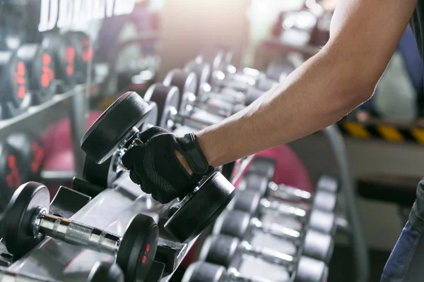 Ásia esporte homem fazendo um braço dumbbell fileiras de metal no moderno g — Fotografia de Stock