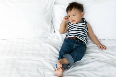 Beyaz yatakta düşünme erkek bebek. kopya alanı.