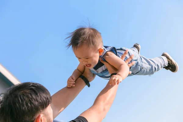 Gelukkig gezin - vader plezier gooit omhoog in de lucht kind. vet — Stockfoto