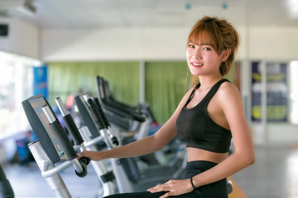 Asiática joven mujer en deporte desgaste haciendo deporte en gimnasio . —  Fotos de Stock