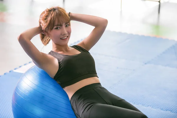 Deportiva chica feliz haciendo situps en el gimnasio . —  Fotos de Stock