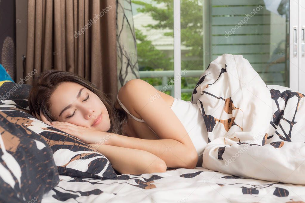 Young asia woman sleeping in her bed, she is resting with eyes c