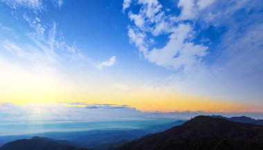 Güneş ışınlarıyla gün batımı, bulutlarla gökyüzü ve güneş.