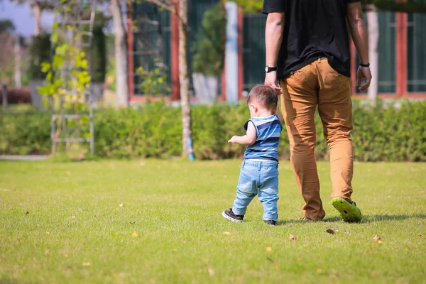 Gelukkig vader en zoontje wandelen in de zomer park. aanneming en — Stockfoto