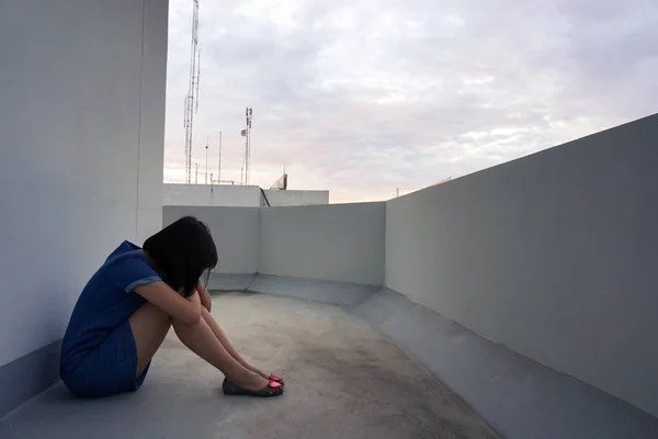 Triste y solitaria mujer en la ciudad sentado lado balcón . — Foto de Stock