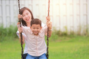 Mutlu aile eğleniyor bir salıncak binen bir Bahçe.