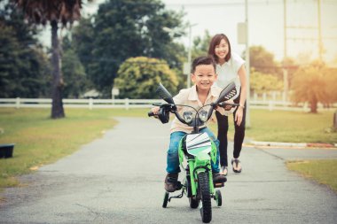 Anne yardım onun sevimli oğlu binmek bisiklet sevgi dolu..