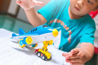 Çocuk evde oyuncaklarla oynuyor..