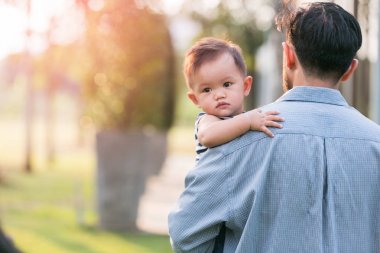 mutlu küçük çocuk ve babası onu par omuzlarında taşıyan