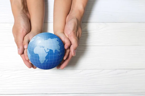 World concept: Two human hands holding global on wooden backgrou — Stock Photo, Image