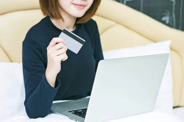 Mains féminines tenant une carte de crédit et utilisant un ordinateur portable. Boutique en ligne pi — Photo