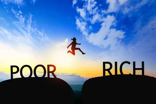 Kvinna hoppa genom klyftan mellan fattiga till rika på sunset. — Stockfoto