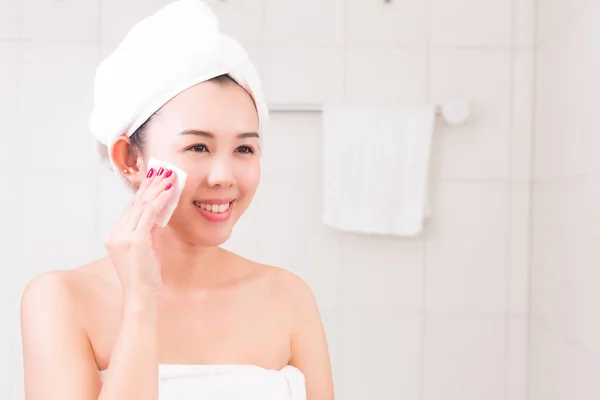 Vacker kvinna applicera kosmetisk kräm i badrum. — Stockfoto