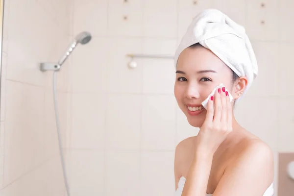 Hermosa mujer quitando el maquillaje de su cara en el baño . — Foto de Stock