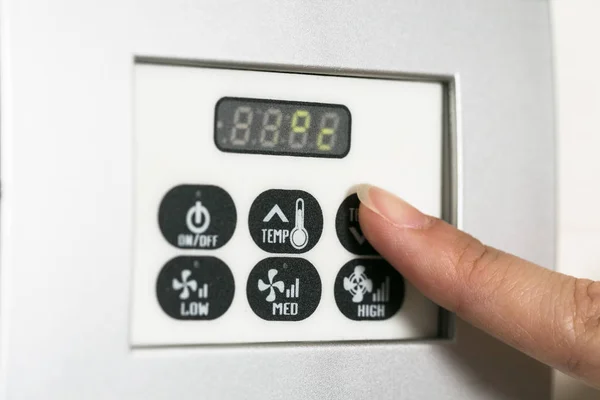 Χέρι αγγίζει την οθόνη ένα ξενοδοχείο θερμοστάτη εξόγκωμα ρύθμισης θερμοκρασίας — Φωτογραφία Αρχείου