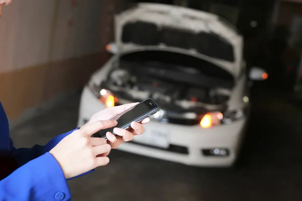 As mãos usando um smartphone chamam uma emergência de carro. Carro avariado — Fotografia de Stock