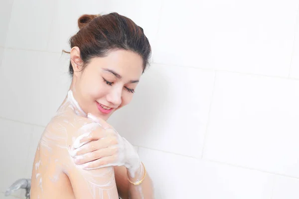 Mulher tomando um banho desfrutando com banho de espuma . — Fotografia de Stock