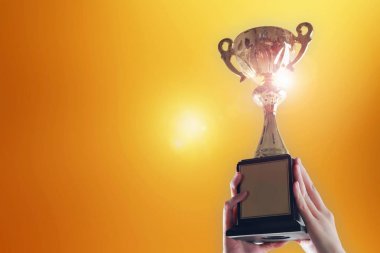 Trophy Kupası altın arka plan üzerinde tutan eller iş.