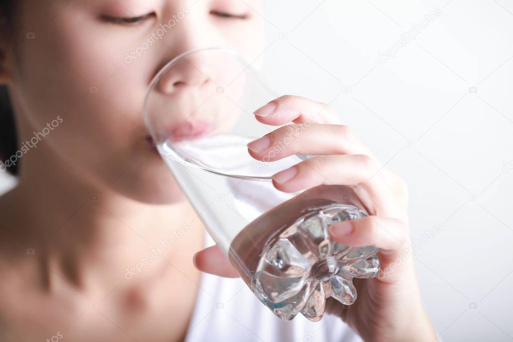 Young woman drinking clean water in her hand.