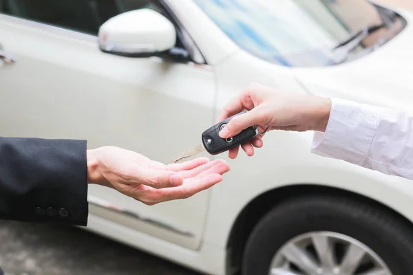 Vendedor que oferece a chave do carro a um homem de negócios do negociante do carro . — Fotografia de Stock