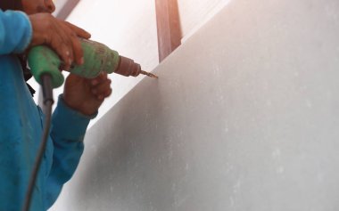 Bir matkap delik duvar karoları yapıyor.