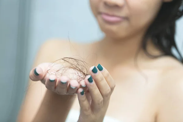Triste jovem segurando seu cabelo longo com olhar para spl danificado — Fotografia de Stock