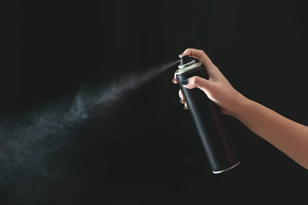 Hand using a spray, isolated on black background. — Stock Photo, Image