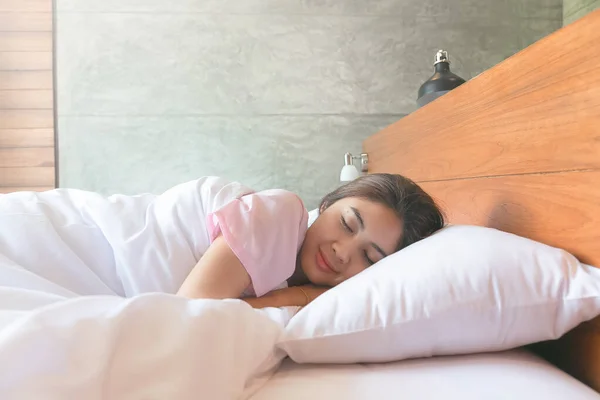 Jovem mulher asiática tem um doce sonho e felicidade na cama no — Fotografia de Stock