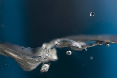 Köpüklü su sıçrıyor. Mavi arkaplanda su damlası.