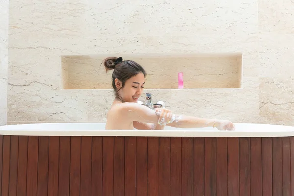Rilassato giovane donna asiatica posa nella vasca da bagno . — Foto Stock