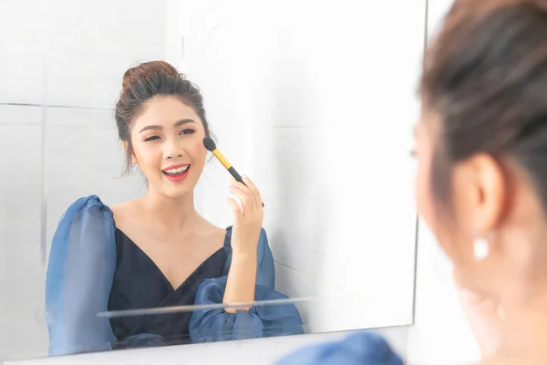 Junge asiatische Frau mit Make-up-Pinsel und Hervorhebung Palette Klo — Stockfoto