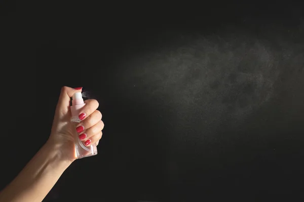 Hand using a spray, isolated on black background. — Stock Photo, Image