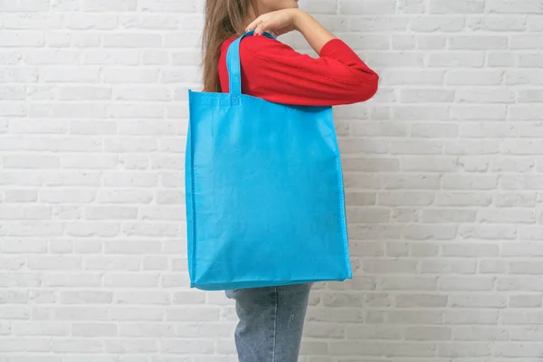 女性はモックアップ空白のテンプレートのためのバッグキャンバス生地を保持しています. — ストック写真