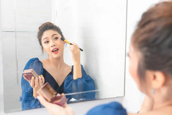 Retrato de uma bela mulher asiática como aplicação de maquiagem perto de um mi — Fotografia de Stock