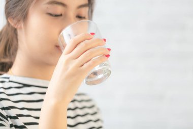 Su içen güzel Asyalı kadın. Yaklaş ve koluna odaklan..