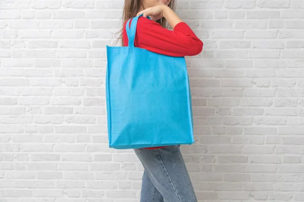 女性はモックアップ空白のテンプレートのためのバッグキャンバス生地を保持しています — ストック写真