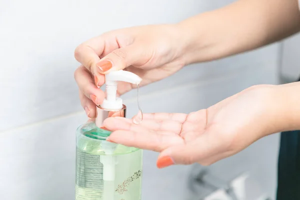 洗面所で手サニタイザージェルポンプディスペンサーを使用して女性の手 — ストック写真