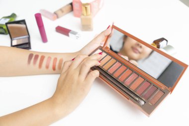 Farklı göz farı testleri yapan el makyajı sanatçısına yakın çekim.