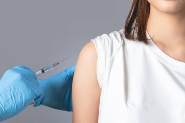 Doktorun bir hastaya iğne yapmasına yakın çekim. Aşılama kavramı