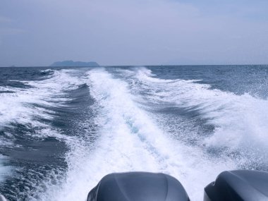 Yüzeydeki deniz suyunda feribot sürat teknesi izi var. Sürat teknesinin arkasındaki beyaz dalga görüntüsü. Seyahat kavramı.