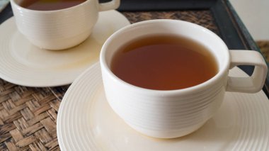 Beyaz fincan sıcak çay, antika masanın üstünde. Sağlıklı çay zamanı..