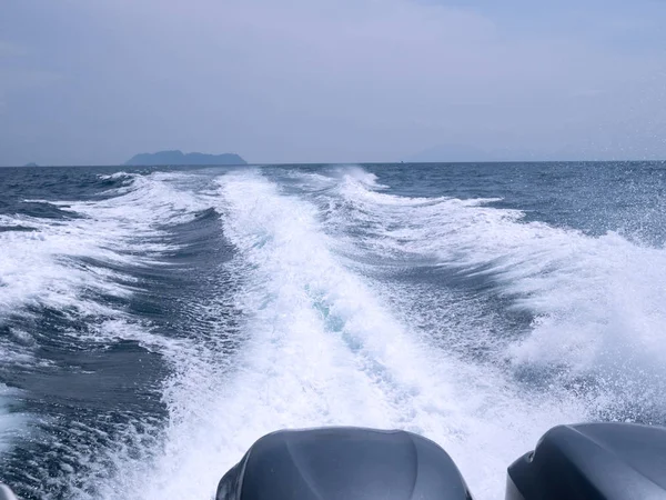 Trace tail of ferry speed boat on surface sea water. White wave view behind speed boat. Travel concept.