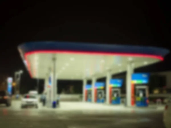 Gece karanlığında bulanık benzin istasyonu.