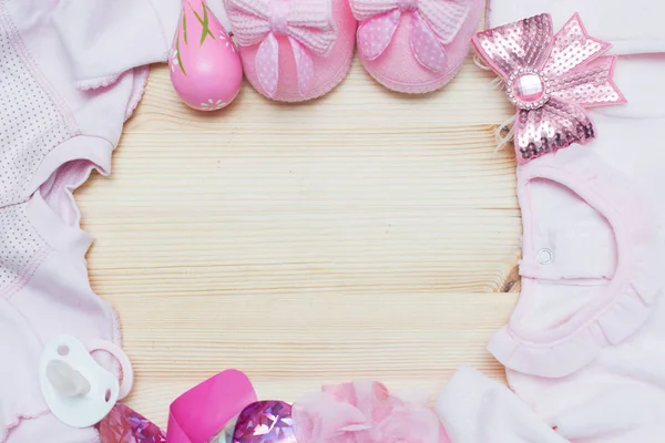 É um tema rosa menina bebê chuveiro ou berçário fundo com bordas decoradas no fundo de madeira . — Fotografia de Stock