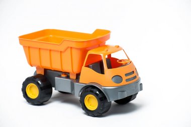 Beyaz arka plan üzerinde plastik turuncu oyuncak kamyon
