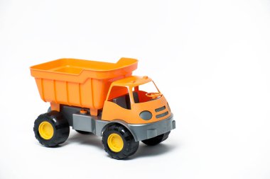 Beyaz arka plan üzerinde plastik turuncu oyuncak kamyon