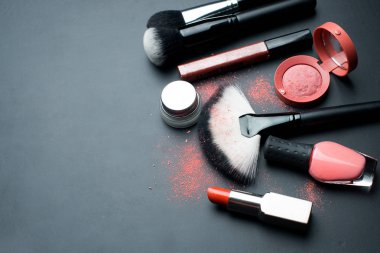 Dekoratif kozmetik ve makyaj fırçaları koyu arka plan üzerinde. Üstten Görünüm